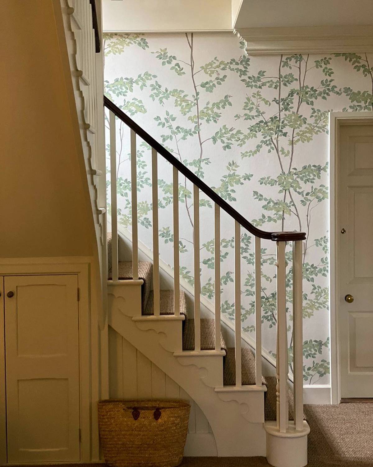 stairs with storage and leaves wallpaper