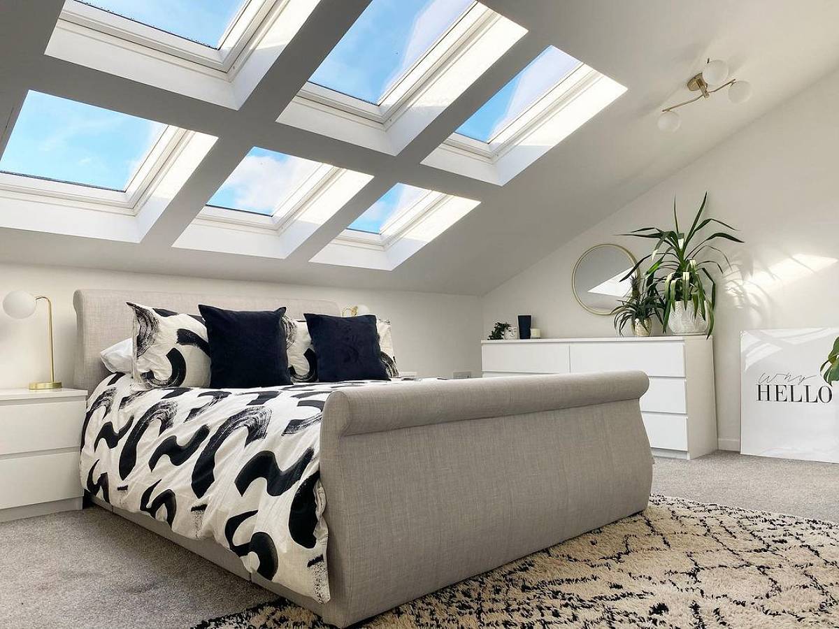 bed under skylight with plants