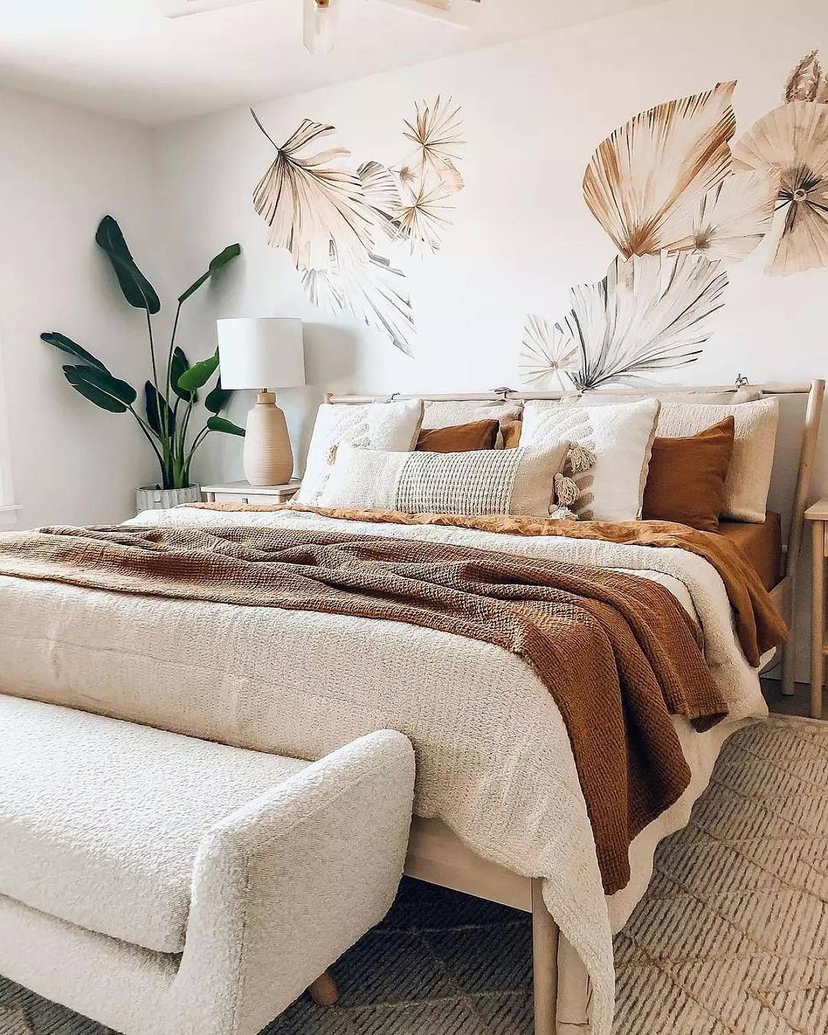 bedroom with leafy wall paint and plant on corner